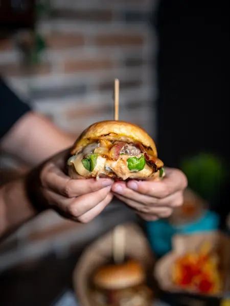 Smash burger u ruci gosta, izbliza